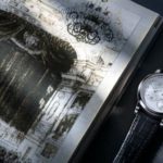 Lange 1 In White Gold Next to A Drawing of The Royal Court Theatre